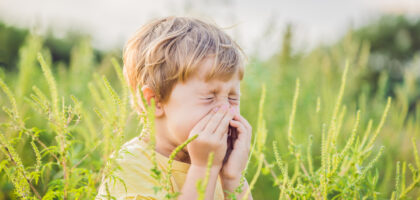 Boy sneezing due to hay fever in Texas fall season.