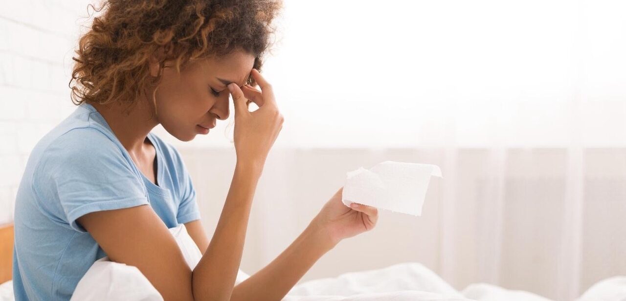 Woman with spring allergy symptoms holding tissue